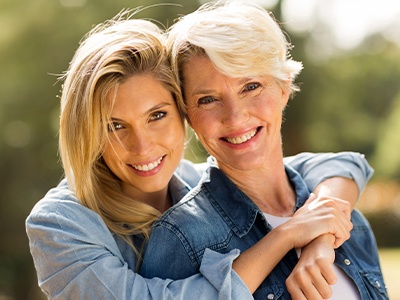 Two women sharing healthy smiles after visiting their Milton dentist