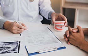 Dentist and patient reviewing dental insurance forms