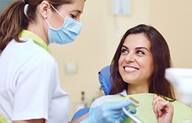 Woman in dental chair smiling at dentist