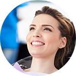 woman smiling while holding dental mirror 
