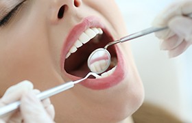 Dentist examining patient's smile after gum recontouring treatment
