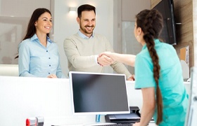 bpatient shaking a dental team member’s hand