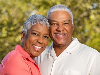 Older man and woman with dentures smiling