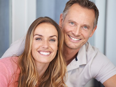 Man and woman smiling after emergency dentistry treatment