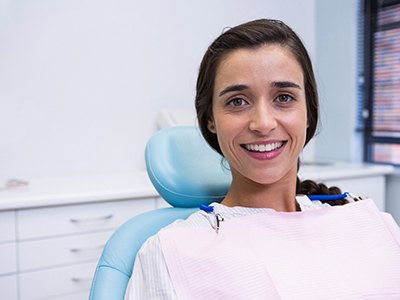 Woman smiling while visiting dentist in Milton