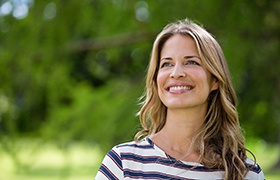 Woman in striped shirt outside smiling