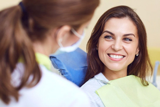 Woman smiling while talking to her dentist