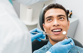 Man looking at dentist during dental checkup and teeth cleaning visit