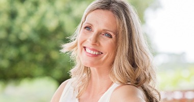 Woman smiling after replacing missing teeth