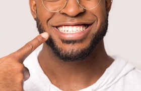 close-up of a man pointing to his smile