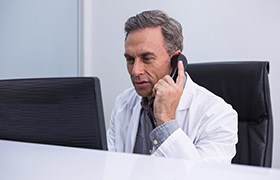 Cosmetic dentist in Milton on phone with patient