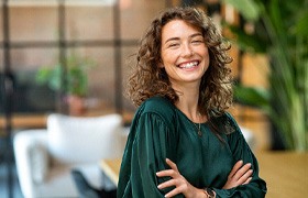 Woman in green shirt smiling in a lounge