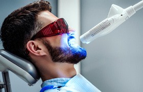 Bearded man undergoing in-office teeth whitening in Milton, MA