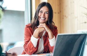 Woman sitting and smiling at her desk