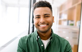 Man in green shirt standing and smiling