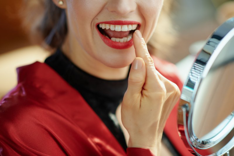 Woman smiling after seeing cosmetic dentist