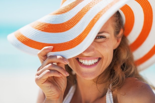 Smiling woman in beach hat.