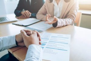 a person interviewing with their resume in front of them and their hands folded together