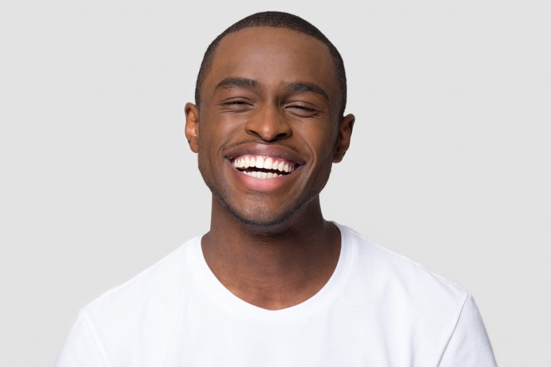 Young man pointing at his white smile