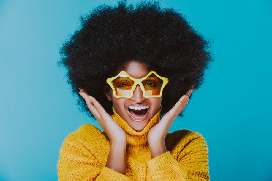 A smiling woman wearing star sunglasses
